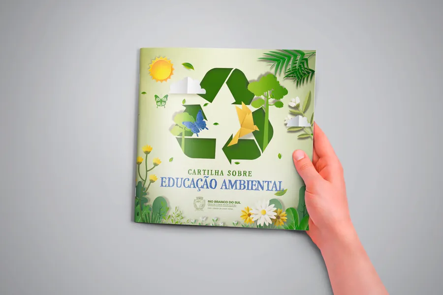 Mão segurando a Cartilha sobre Educação Ambiental de Rio Branco do Sul
